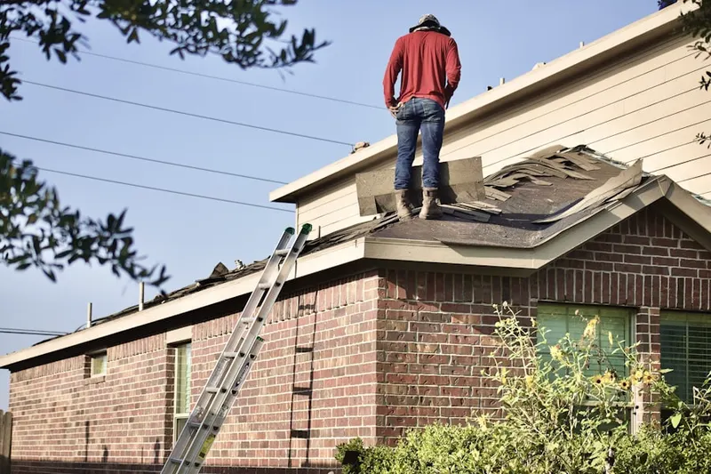 Professional roofer working on a residential roof in Bryant School